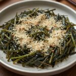 접시에 담긴 완성된 달래오이무침, 통깨가 뿌려져 있다