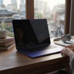 인디고 색상 맥북 네오가 나무 책상 위에 놓여 있는 모습