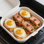 에어프라이어로 구운 스카치 에그와 연어 파피요트가 담긴 피크닉 도시락