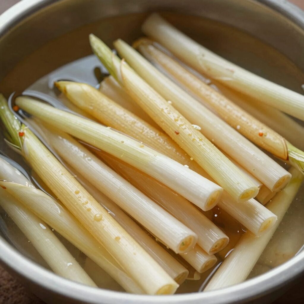 감자칼로 채썬 마늘쫑과 통마늘쫑을 간장 절임물에 담가 장아찌를 만드는 과정