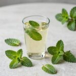 페퍼민트 잎과 차 한 잔이 놓인 테이블 위의 모습