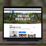 템플스테이 홈페이지 예약 화면, 행복두배 프로그램 배너와 지역 선택 필터가 보이는 컴퓨터 모니터