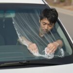 황사 시즌에 차량 앞유리에 워셔액을 뿌리는 모습