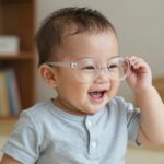 아기가 유아선글라스를 착용하고 밝게 웃고 있는 모습