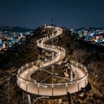 야간에 조명이 켜진 용왕산스카이워크 달팽이 모양 데크와 서울 야경