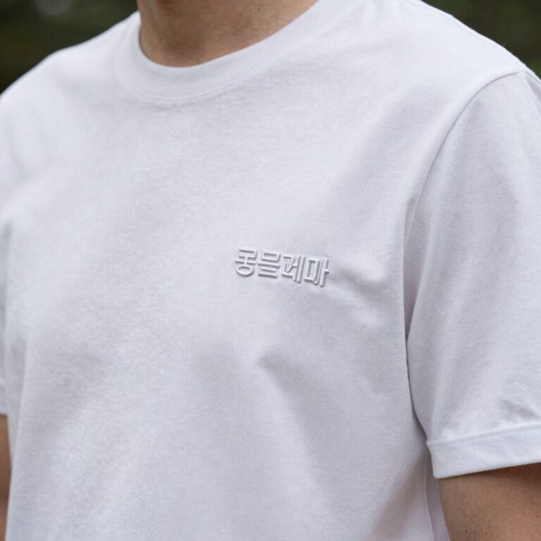 몽클레어 흰색 카라티 가슴 로고 패치와 소매 삼선 디테일 확대 사진