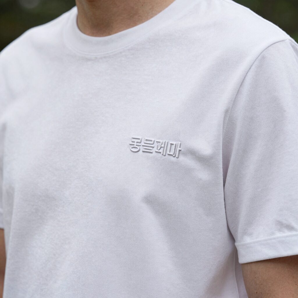 몽클레어 흰색 카라티 가슴 로고 패치와 소매 삼선 디테일 확대 사진