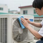 에어컨 실외기 냉각핀에 먼지가 쌓인 모습을 부드러운 솔로 청소하는 모습