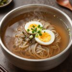 풀무원 함흥 비빔냉면을 그릇에 담고 초절임무와 고기를 곁들인 모습