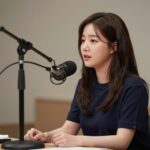 성시경이 스튜디오에서 마이크 앞에 앉아 방청객에게 노래를 부르는 모습, 고막남친 콘셉트를 보여주는 사진