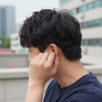 머리를 옆으로 기울이고 손으로 귀를 잡아당겨 물을 빼는 자세