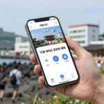 10월 제주도 항공권 예매를 위해 스마트폰으로 항공사 앱을 보고 있는 여행자의 손