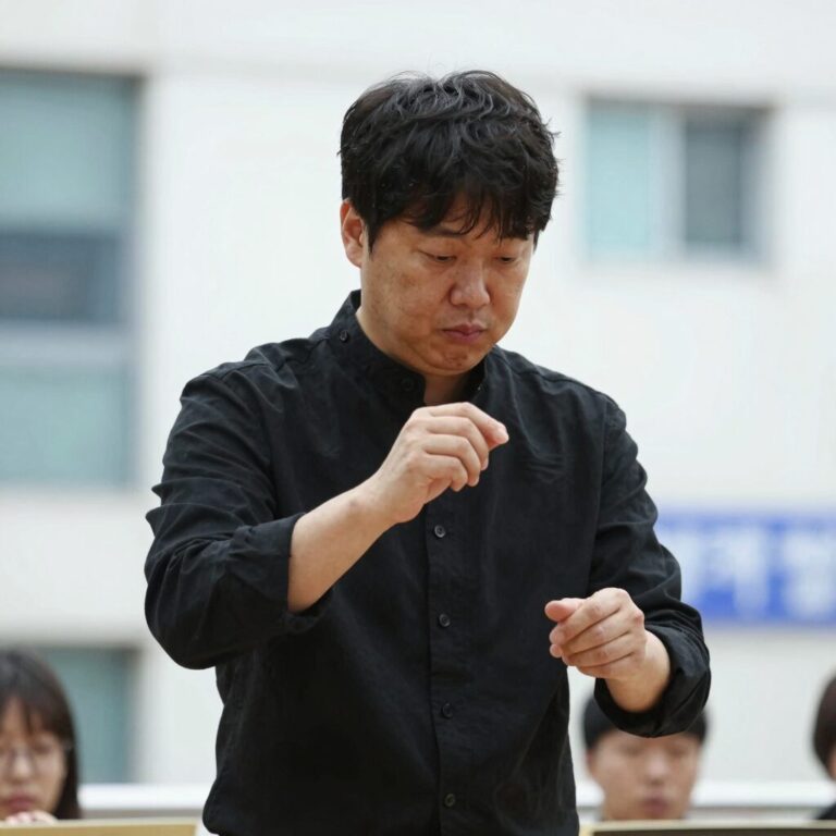 정명훈 지휘자가 오케스트라를 지휘하는 모습, 손과 표정에 집중력이 드러난다
