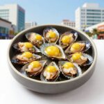 완성된 전복내장죽 그릇에 담긴 모습, 전복살과 계란 노른자가 토핑되어 있다